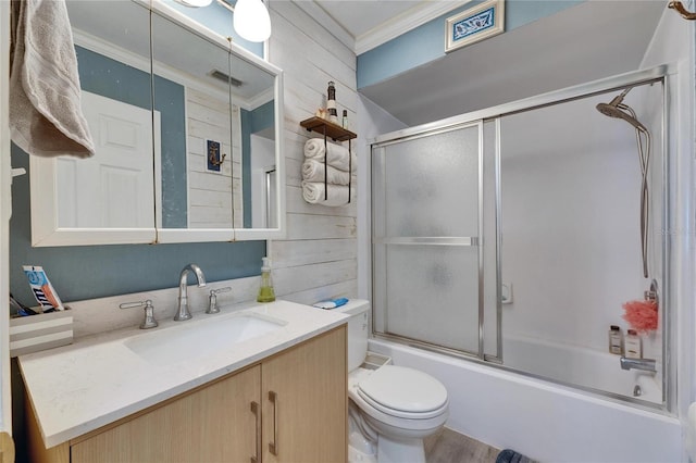 bathroom with visible vents, bath / shower combo with glass door, toilet, ornamental molding, and vanity