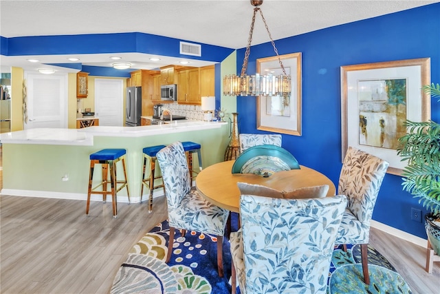 dining space featuring visible vents, baseboards, and light wood-style floors