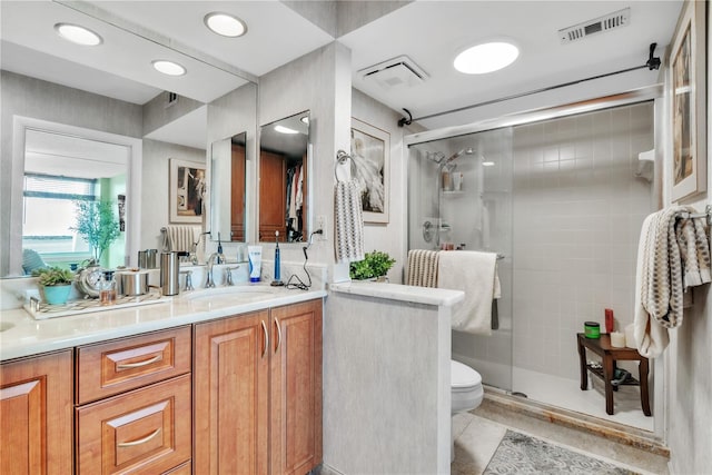 full bathroom featuring visible vents, a stall shower, toilet, and vanity