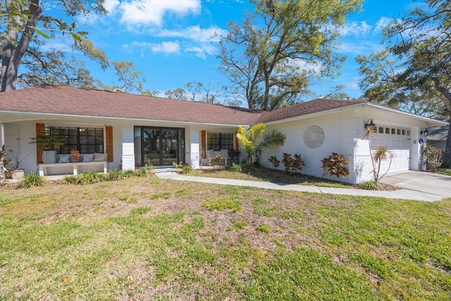 view of front of home with driveway, a front lawn, and an attached garage