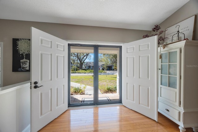 entrance foyer featuring light wood-style flooring and a textured ceiling