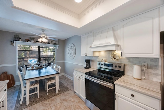 kitchen with stainless steel electric range, decorative backsplash, a raised ceiling, custom exhaust hood, and ceiling fan