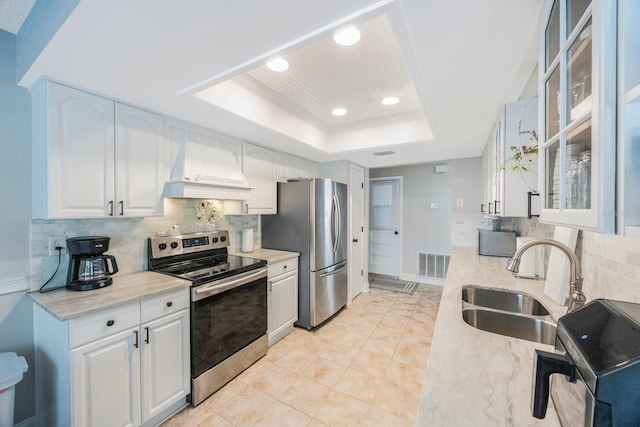 kitchen with visible vents, a tray ceiling, custom exhaust hood, stainless steel appliances, and a sink