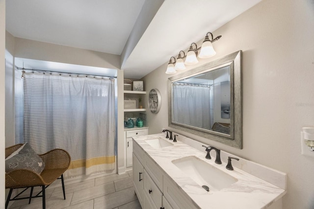 full bath featuring a sink, a shower with curtain, and double vanity