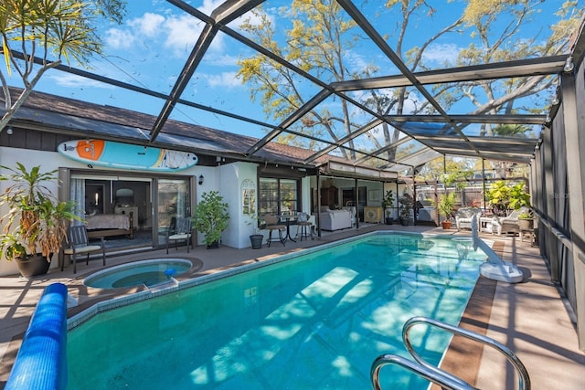 outdoor pool with glass enclosure, a patio, and an in ground hot tub