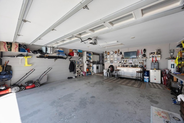 garage with a workshop area, a garage door opener, and water heater