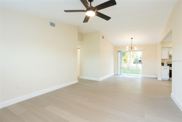 empty room with visible vents, baseboards, light wood-type flooring, lofted ceiling, and ceiling fan with notable chandelier