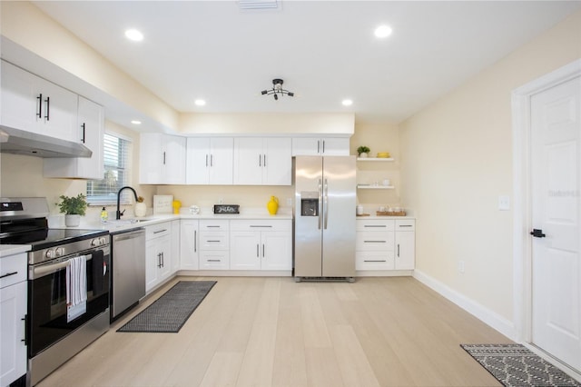 kitchen featuring under cabinet range hood, light countertops, appliances with stainless steel finishes, white cabinetry, and a sink