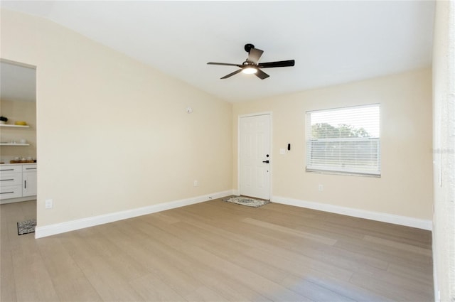 interior space with baseboards, light wood-style floors, and a ceiling fan