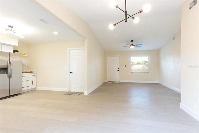 interior space with visible vents, ceiling fan with notable chandelier, light wood-style flooring, and baseboards