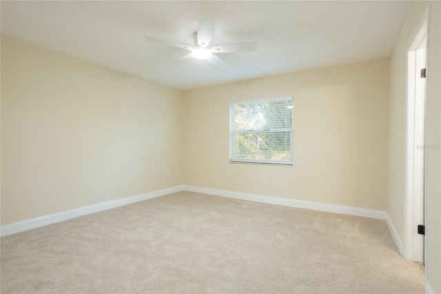 unfurnished room with ceiling fan, baseboards, and light carpet