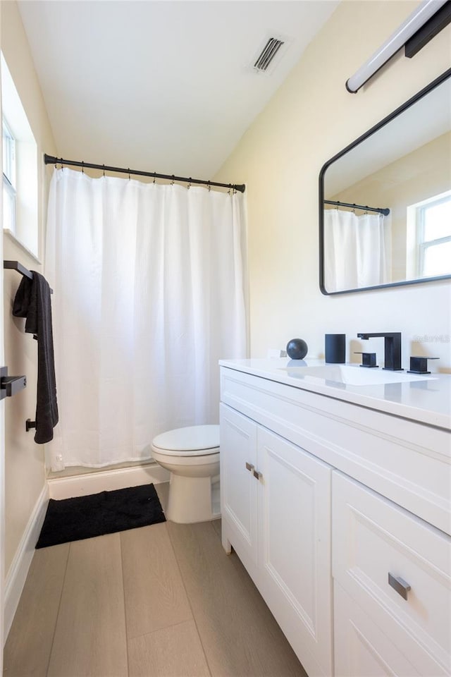 full bath featuring visible vents, toilet, a shower with shower curtain, wood finished floors, and vanity