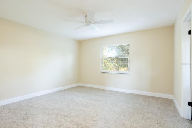 spare room with light carpet, baseboards, and ceiling fan