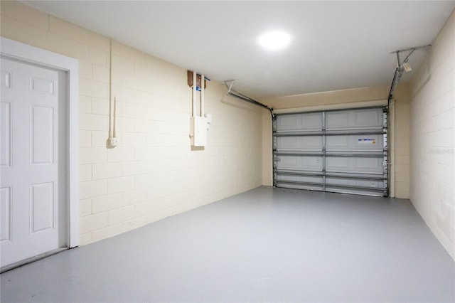 garage with electric panel and concrete block wall