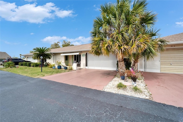 view of front facade featuring concrete driveway, stucco siding, a garage, and a front lawn