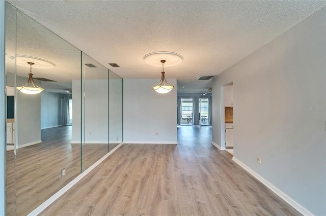 interior space with visible vents, light wood finished floors, and a textured ceiling