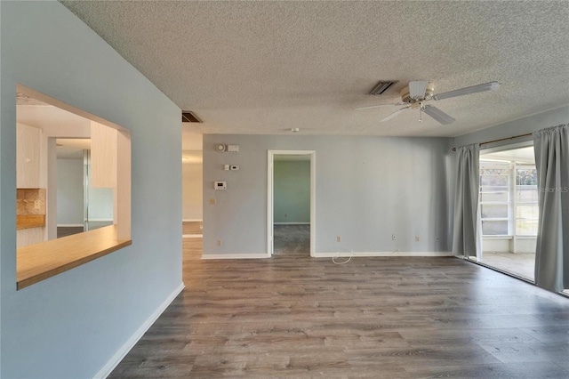 unfurnished room with visible vents, baseboards, a ceiling fan, and wood finished floors