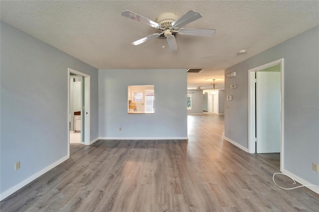 spare room with a ceiling fan, wood finished floors, visible vents, and a textured ceiling