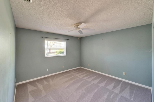 unfurnished room featuring a ceiling fan, baseboards, carpet floors, and a textured ceiling