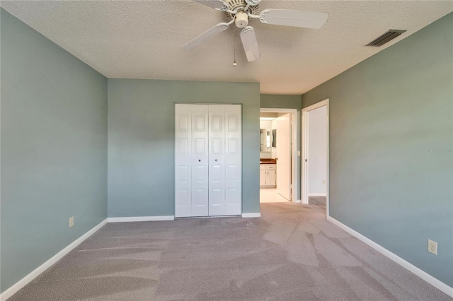 unfurnished bedroom featuring baseboards, visible vents, a closet, and a textured ceiling