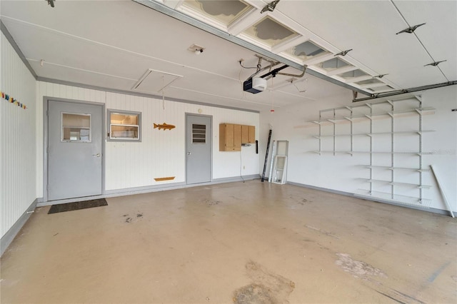 garage with a garage door opener and baseboards