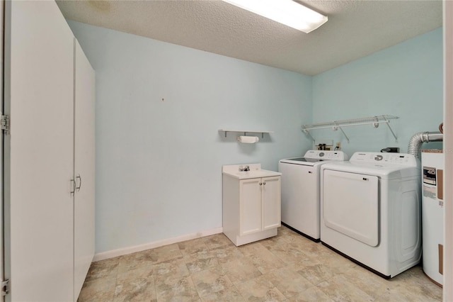 laundry area featuring independent washer and dryer, electric water heater, a textured ceiling, cabinet space, and baseboards