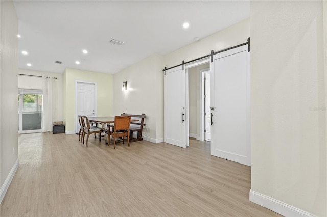 dining space featuring visible vents, recessed lighting, a barn door, light wood-style floors, and baseboards