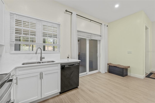 kitchen featuring light wood finished floors, a sink, stove, white cabinets, and black dishwasher