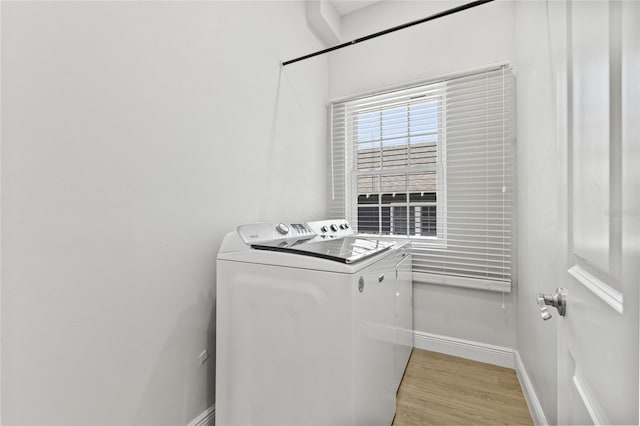 laundry room with laundry area, light wood-style flooring, baseboards, and separate washer and dryer