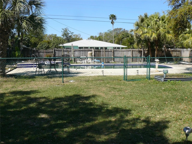 view of swimming pool with a lawn, a fenced in pool, and fence