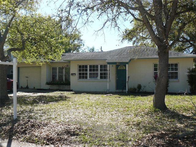 ranch-style house featuring a garage and stucco siding