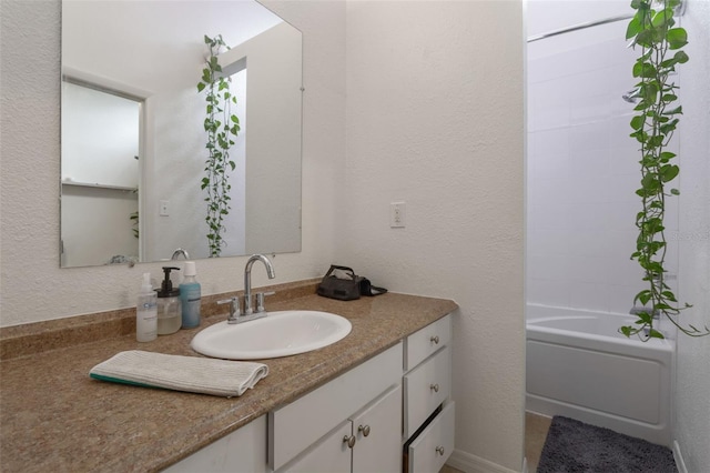 full bathroom with vanity and a textured wall