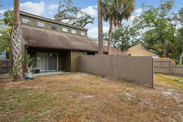 back of house featuring roof with shingles and fence