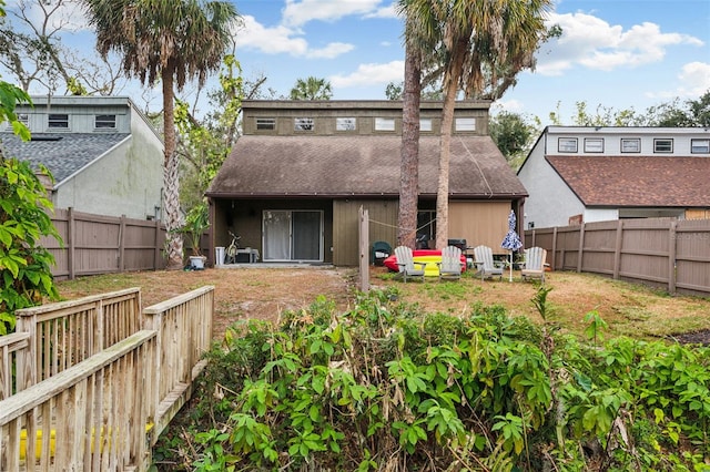 back of property featuring a shingled roof and a fenced backyard