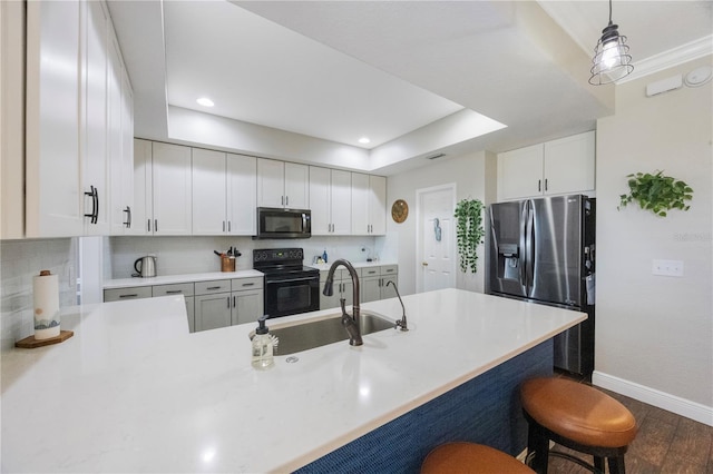 kitchen featuring backsplash, a kitchen breakfast bar, stainless steel refrigerator with ice dispenser, black / electric stove, and a sink