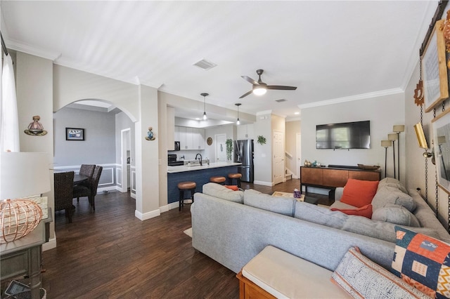 living area with a ceiling fan, visible vents, arched walkways, ornamental molding, and dark wood-type flooring