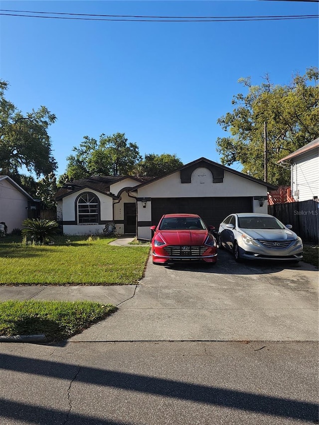 ranch-style house featuring fence, an attached garage, stucco siding, concrete driveway, and a front lawn