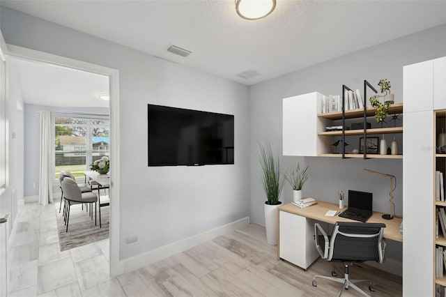 office space with visible vents, baseboards, and a textured ceiling