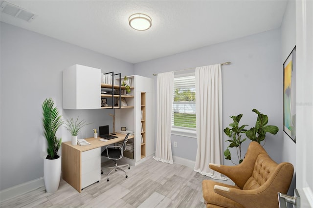 office area featuring baseboards, visible vents, and light wood finished floors