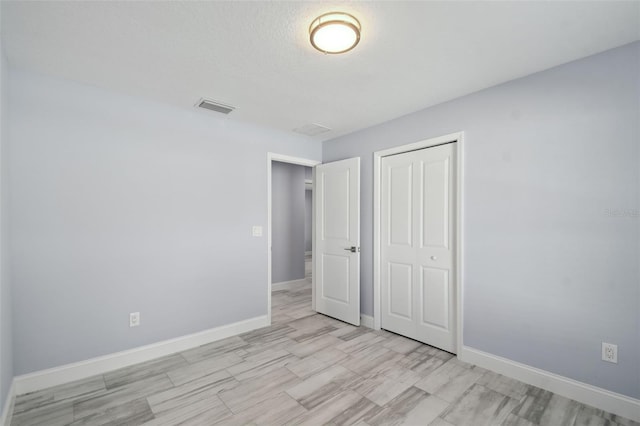 unfurnished bedroom featuring a closet, visible vents, and baseboards