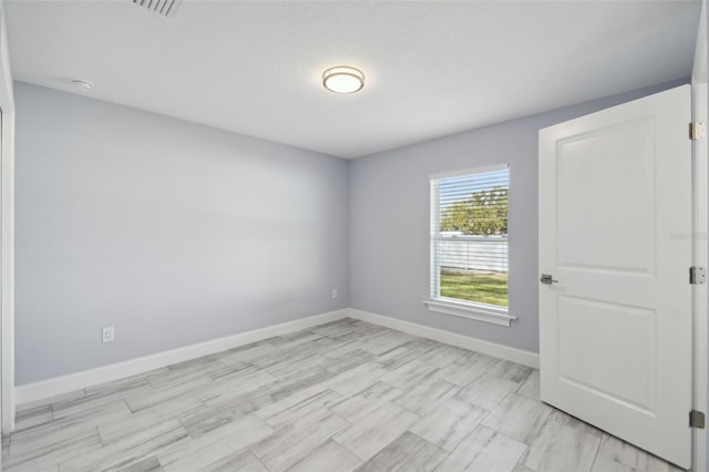 spare room featuring visible vents and baseboards