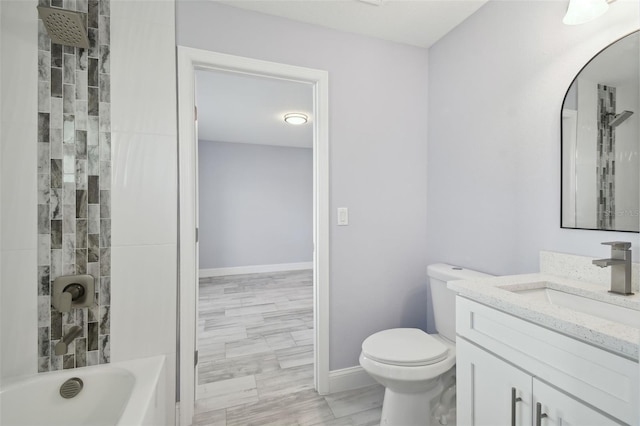 bathroom featuring shower / washtub combination, toilet, vanity, and baseboards