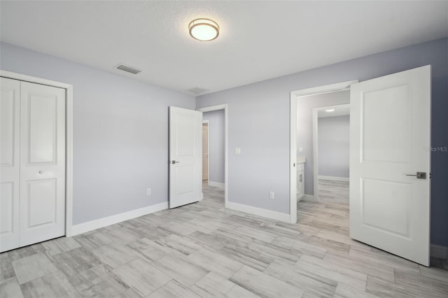 unfurnished bedroom featuring visible vents, baseboards, and a closet