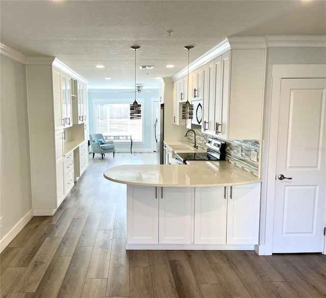 kitchen with stainless steel appliances, crown molding, and white cabinetry