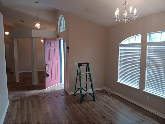 foyer featuring baseboards, wood finished floors, and a chandelier