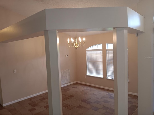 unfurnished dining area featuring an inviting chandelier, baseboards, and visible vents