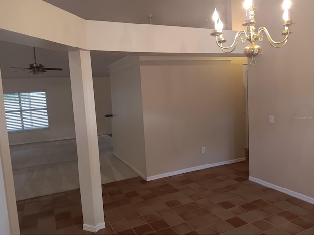 empty room featuring baseboards and ceiling fan with notable chandelier