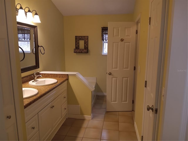 full bath with a sink, baseboards, double vanity, and tile patterned floors