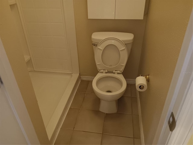 bathroom with tile patterned flooring, toilet, and baseboards