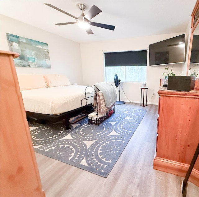 bedroom featuring baseboards, ceiling fan, and wood finished floors